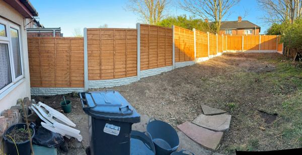 Panoramic view of a cleared back garden with new fence panels along the side and rear boundaries