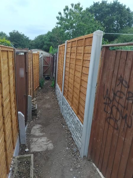 Side passage with new lap fence panels, concrete posts and stone-effect gravel boards beside a darker fence